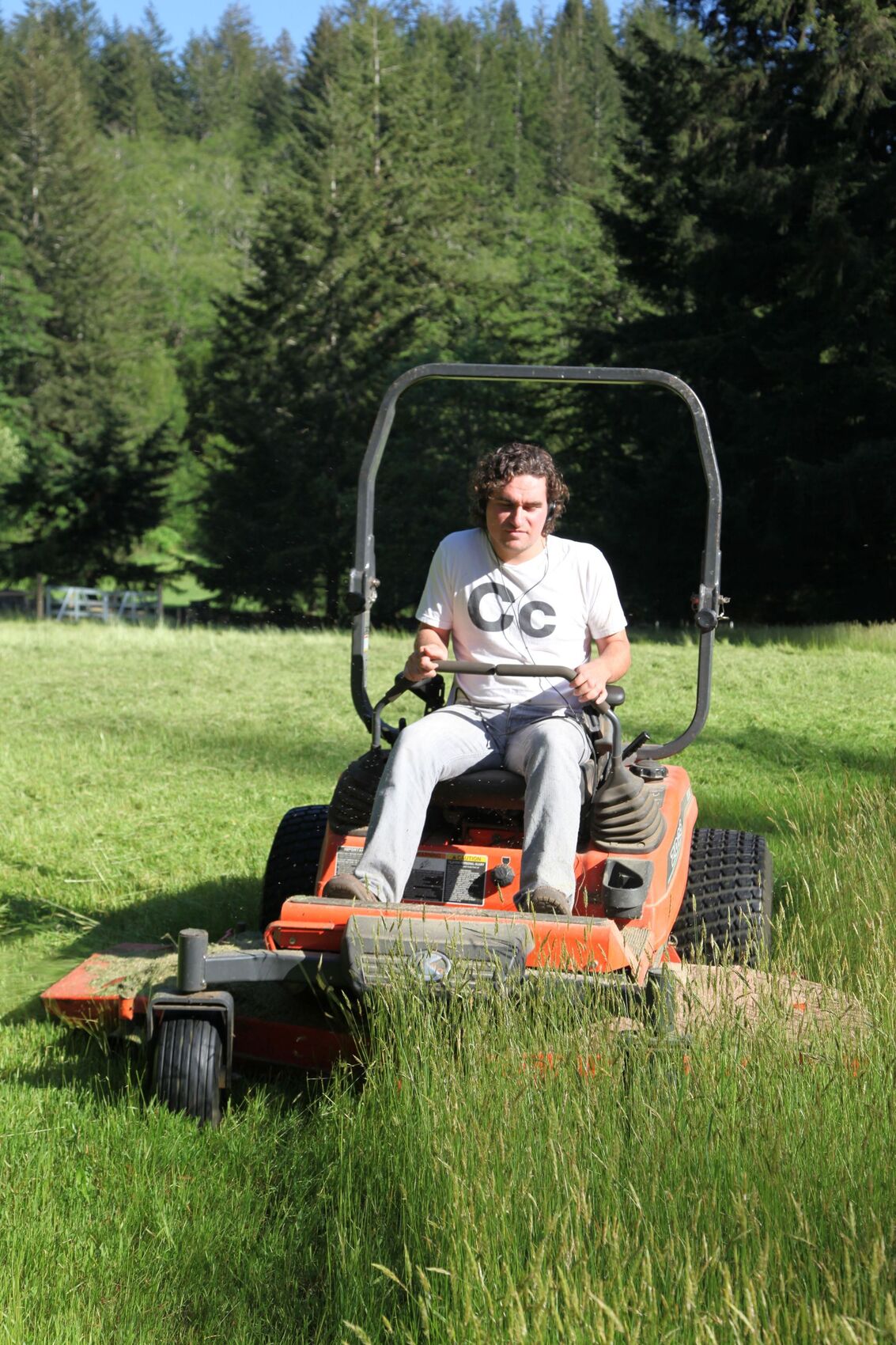 Commercial riding mower cutting clean stripes into a large lawn