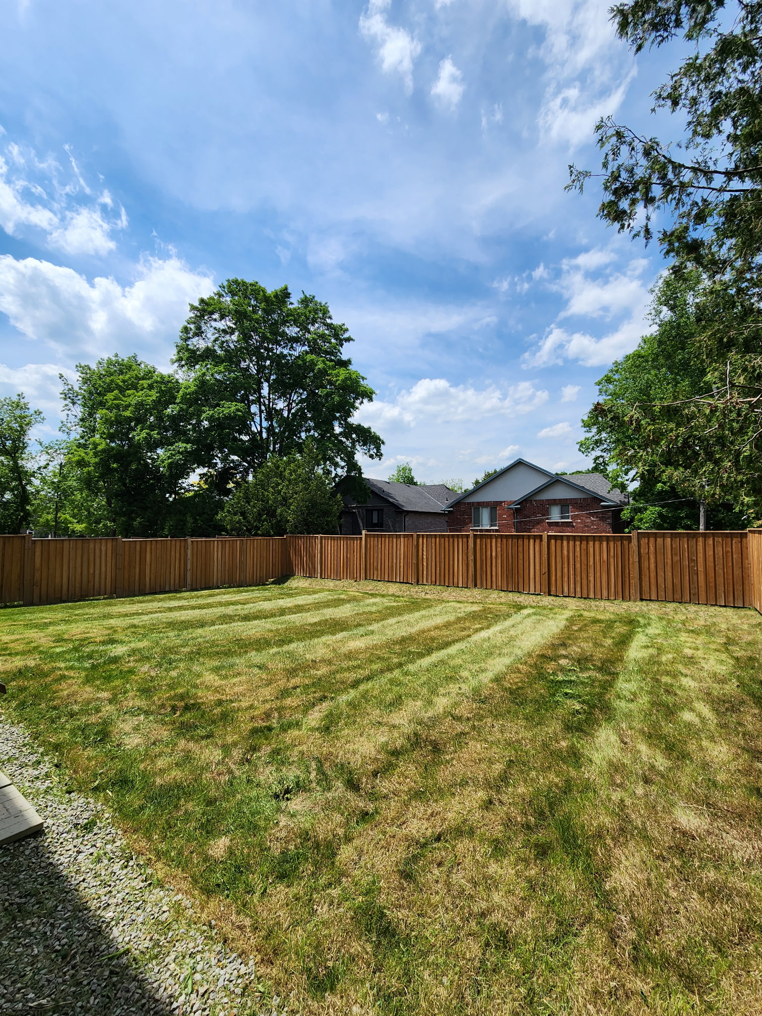 Fenced residential backyard with freshly cut grass